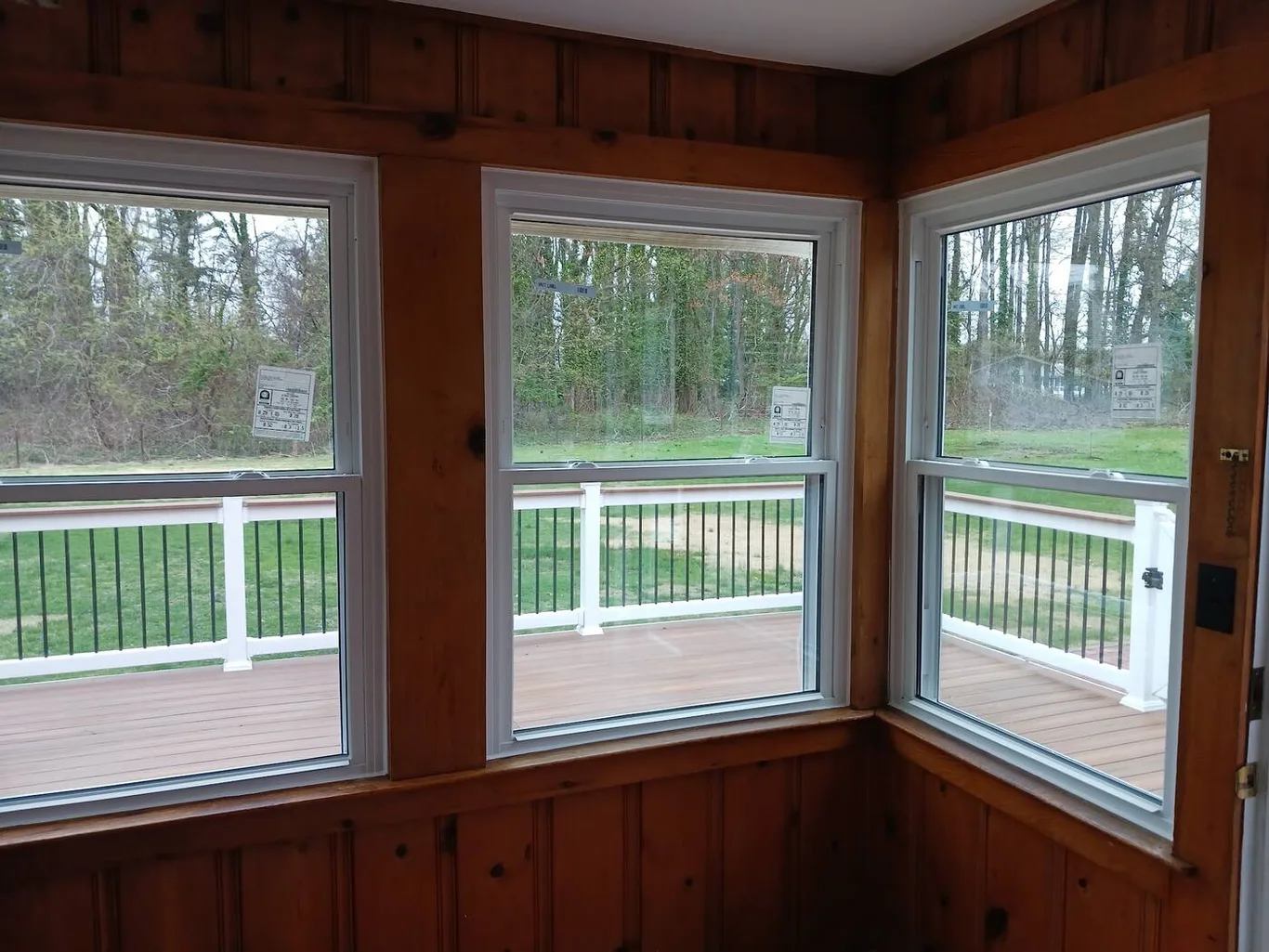 A corner room with three new windows looking out on a deck