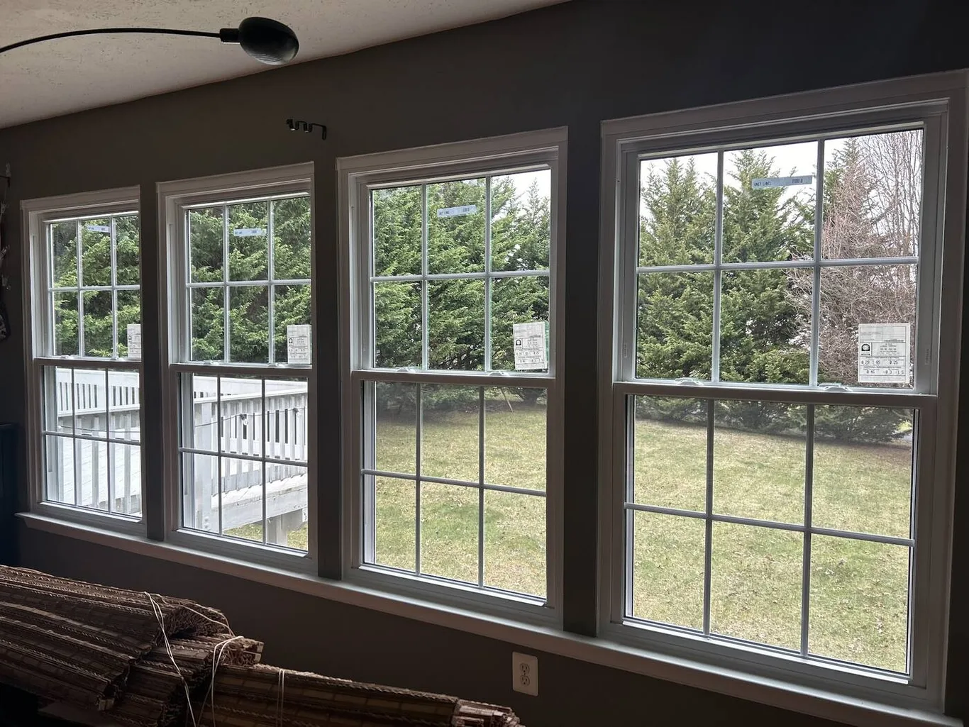Four new double-hung windows side by side, looking out on a lawn