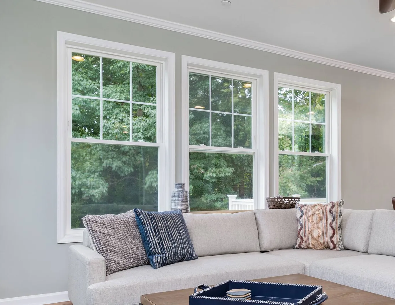 Three tall double-hung windows along a living room wall
